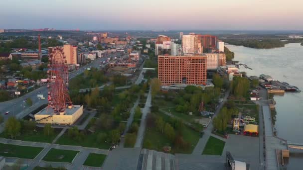 Tirer sur les autoroutes et les rues de la ville près du bord de la rivière d'une hauteur. Coucher de soleil — Video