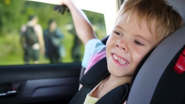 Il bambino va in un seggiolino in macchina. Viaggio in famiglia — Video Stock