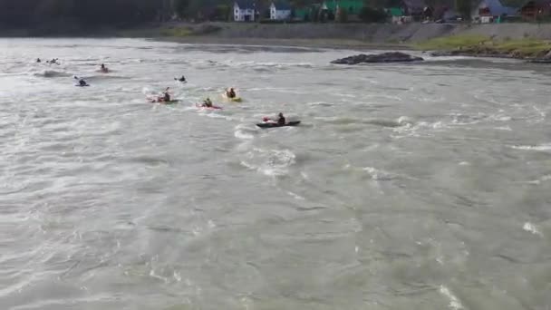 Grupa ludzi płynie nadmuchiwaną łodzią po górskiej rzece. Rafting sportowy — Wideo stockowe