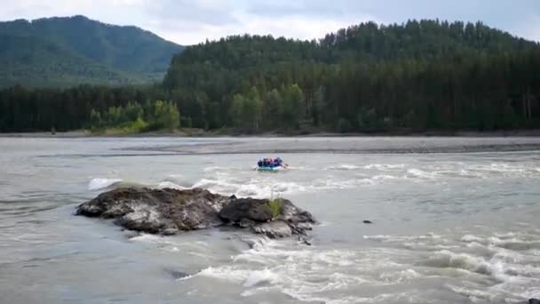 Grupa ludzi płynie nadmuchiwaną łodzią po górskiej rzece. Rafting sportowy — Wideo stockowe