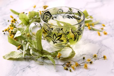 Bir fincan limon çay ve kuru ıhlamur çiçeği.