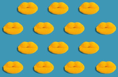 Mavi bir arka plan üzerinde örme sarı dudaklar.