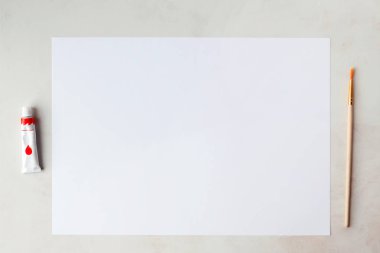 Çizim için ayarlayın. Beyaz kağıt, guaş ve üstten çekilen bir fırça.