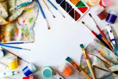 Çizim için ayarlayın. Beyaz kağıt, guaş, suluboya ve üstten çekilen fırçalar.