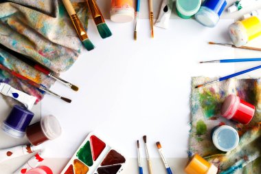 Çizim için ayarlayın. Beyaz kağıt, guaş, suluboya ve üstten çekilen fırçalar.