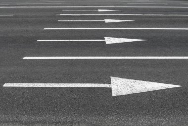 Siyah asfalt üzerinde yol işaretleri Okları