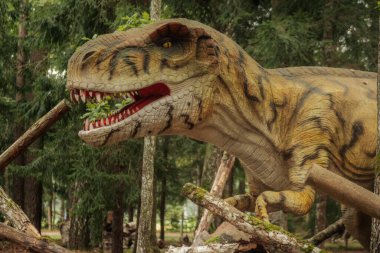 Bir dinazor modelinin yüzünün detaylı bir yakın çekimi, dikey gözbebeği ve loş ışıkta dokulu sürüngen derisi ile sarı gözünü vurguluyor.. 