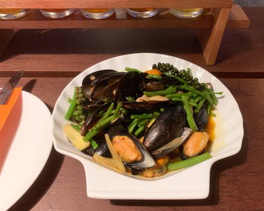 Kabuklu deniz tarağı ile karıştırılmış midye. Kabuklu tabakta servis edilir.