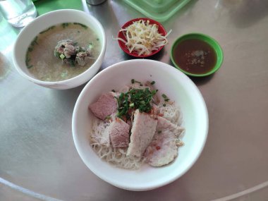 Domuz etli kuru pirinç eriştesi. Domuz kemiği çorbası ile servis ediliyor.