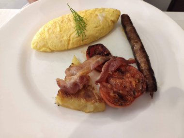 Omlet, domuz pastırması ve sosisli büfe kahvaltısı.