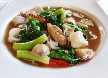 Lezzetli sos, karides, mürekkep balığı ve midyeli Tayland usulü kızarmış geniş erişte..