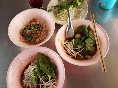 Yerel bir erişte dükkanında servis edilen Tayland usulü domuz etli şehriye ve baharatlı kuru erişte..