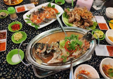 Limonlu haşlanmış balık, peygamber devesi karidesi ve baharatlı turşulu yengeç içeren yerel deniz ürünleri tabağı..