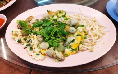Oyster omelette with eggs, soft batter, fresh oysters, spring onions, and bean sprouts.