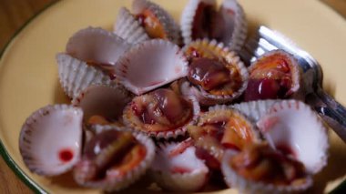 Kremalı bir kâsede sunulan taze midyelerin yakın çekimi doğal dokularını ve tuzlu, zengin cazibelerini gözler önüne seriyor. Deniz ürünleri temalı içerik, mutfak videoları veya restoran promosyonları için mükemmel..