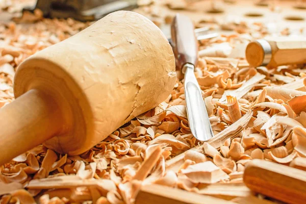 Keskiler ahşap talaşı masanın üstüne koydu. Talaş içinde yalan araçları oyma. Bir oyma atölyede. Ihlamur ahşap kesme. Bir oyma atölye çalışmaları duba üzerinde tahta tokmak.