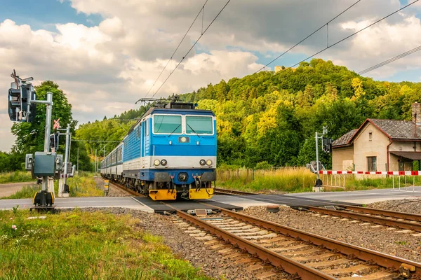 Geçiş Engelleri Ile Gelen Mavi Elektrikli Tren Yeşil Vadi Boyunca Stok Fotoğraf