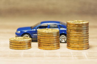 Araba modeli ve sikke satın alma veya bir araba kiralama bir kavram olarak ahşap bir masa üzerinde. Bir araba satın almak için kredi. Çek para masada. Para ile mali kavramı. Altın sikke.