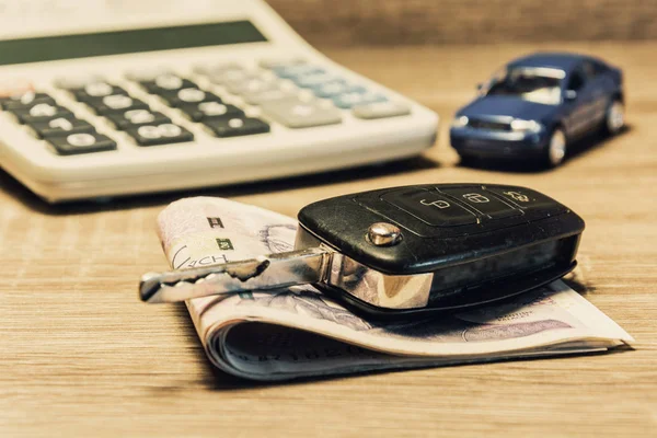 Car keys, banknotes, car model, and calculator as the concept of buying or renting a car. Loan for buying a car. Czech money at the table. Financial concept with money.