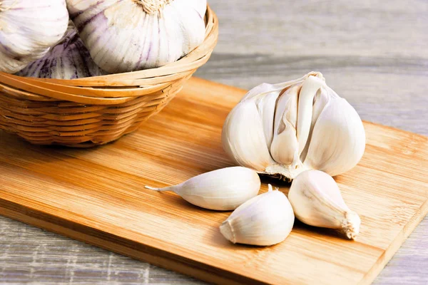 Garlic and garlic cloves on a wooden cutting board