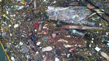 Bali, Endonezya-25 Eylül 2025: Benoa limanındaki plastik atık ve organik atıklar gibi çeşitli yüzen atıklarla dolu kirlenmiş deniz suyu yüzeyi görüntüleri, Denpasar Bali.