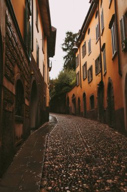 Dikey turuncu güneş ışığı Ortaçağ sokak İtalyan şehir Bergamo.