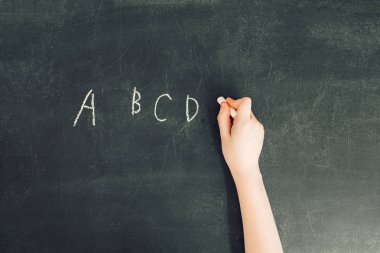 çocuğun el ile tebeşir yazmak harf a, b, c, d siyah kara tahta, stok fotoğraf görüntü