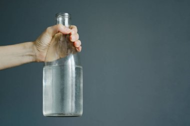 kadının el ile kopya alanı, stok fotoğraf görüntü gri duvar zemin üzerine su şişe tutan