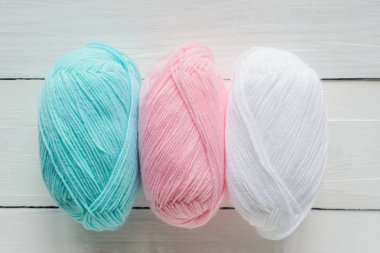 örgü Hank çizgi üzerinde beyaz ahşap arka plan, pastel mavi, pembe ve beyaz renkler, en iyi görünümü kadar yakın düz yatıyordu, stok fotoğraf resim