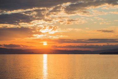 Rusya'nın Novorossiysk şehri üzerinde denizden gün batımına manzara