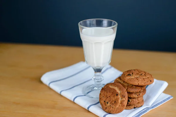 Cookies stack with raisins and milk on rag on table — Stock Photo, Image