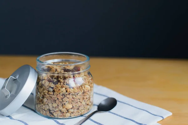 Granola with peanuts, hazelnuts, oat and wheat flakes in glass jar — Stock Photo, Image