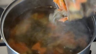 kafkas kadın metal kase kaynar suda renkli yay makarna farfalle koyar, full hd stok video görüntüleri üst görünümü kadar yakın