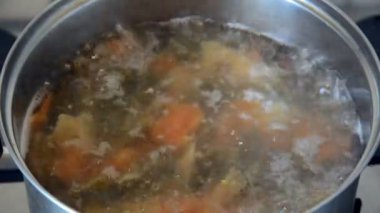 tahta kaşıkile kafkas kadın metal kase kaynar suda renkli yay makarna farfalle karıştırır, full hd stok video görüntüleri üst görünümü kadar yakın