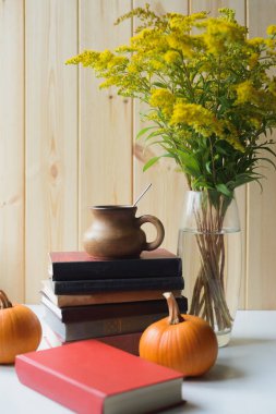 kitap, kabak, fincan, solidago buketi ile sonbahar natürmort