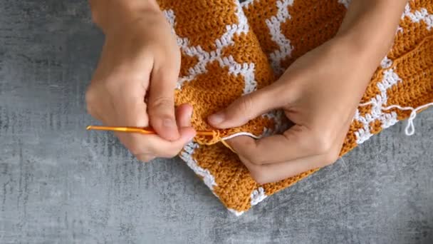 Jonge Vrouwen Handen Haakvideo Met Oranje Witte Katoenen Draad Stenen — Stockvideo