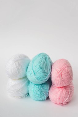 akrilik yumuşak pastel pembe, gök mavisi ve beyaz renkli yün iplik şeritleri beyaz arkaplan, kenar görünüm, metin için metin alanı ile dikey stok fotoğraf