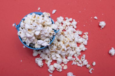 Metalik mavi kovada patlamış mısır taneleri