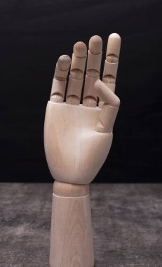 Koyu arkaplanda tahta manken eli var.