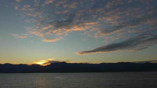 El sol del amanecer pintó nubes rosadas sobre el mar y las montañas . — Vídeos de Stock