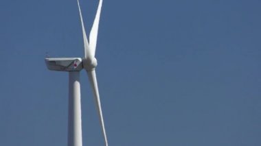 Rüzgar türbini mavi gökyüzü, yakın çekim, yan görünüm karşı.