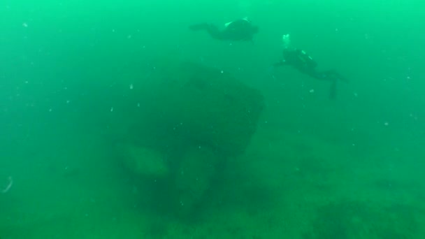 Dos buceadores cerca de la popa de un submarino hundido. — Vídeos de Stock