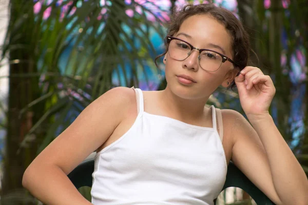 Hermosa enescente sentada en un jardn