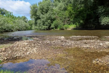 Temiz suyu olan sığ bir nehir ve küçük taşlarla kaplı çamurlu bir taban sık ağaçlar ve çalıların arasından akar. Nehir yatağının bir kısmı kuruyor ve küçük adalar oluşturuyor..