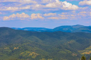 Zümrüt yeşili ormanlarla kaplı yuvarlanan bir dağ silsilesi huzur ve sükunet sağlayan etkileyici bir panoramik manzara yaratır..
