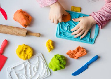 Renkli kil ile çocuğun el. Çocuk oyun ve oyun hamuru vagetables oluşturma. Modelleme kil kalıplama kız. Kil ev