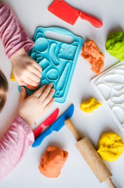 Renkli kil ile çocuğun el. Çocuk oyun ve oyun hamuru vagetables oluşturma. Modelleme kil kalıplama kız. Kil ev