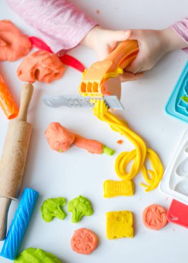 Renkli kil ile çocuğun el. Çocuk oyun ve oyun hamuru vagetables oluşturma. Modelleme kil kalıplama kız. Kil ev