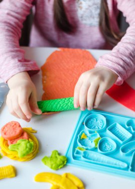 Renkli kil ile çocuğun el. Çocuk oyun ve oyun hamuru vagetables oluşturma. Modelleme kil kalıplama kız. Kil ev