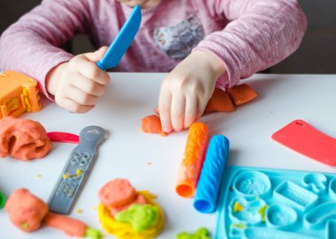 Renkli kil ile çocuğun el. Çocuk oyun ve oyun hamuru vagetables oluşturma. Modelleme kil kalıplama kız. Kil ev